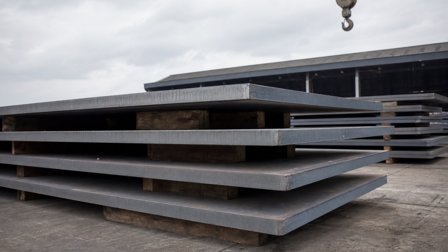 lsaw vs ssaw pipe - heavy steel plate stacked in a pipe mill yard before LSAW forming