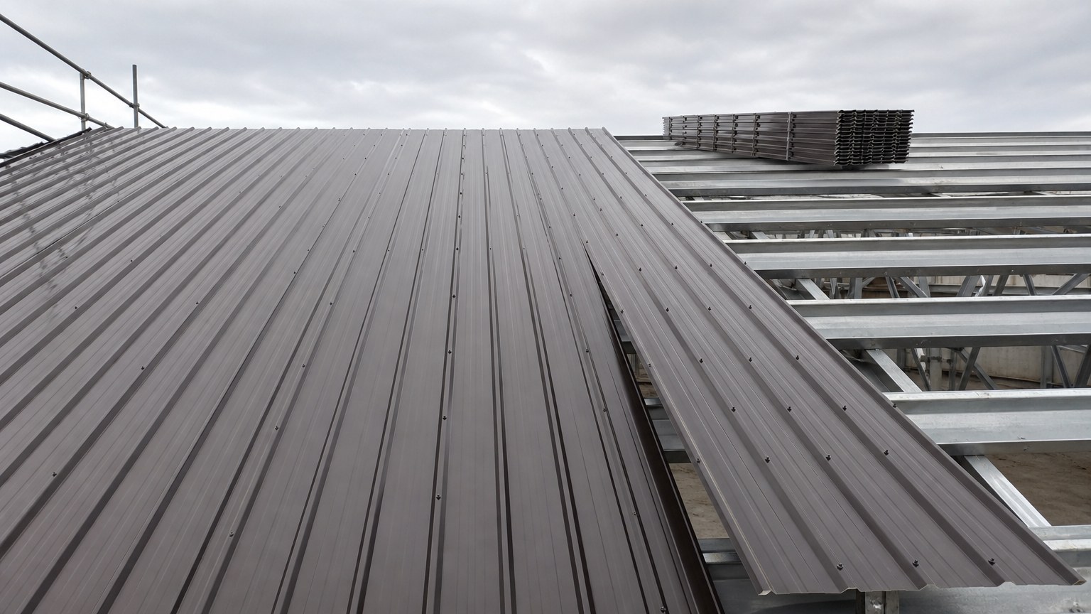 corrugated vs trapezoidal roofing sheet - trapezoidal profiled roofing sheet installed on steel purlins of an industrial building